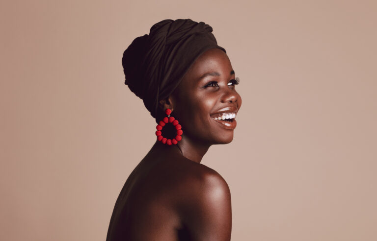 Close,Up,Of,Smiling,African,Woman,On,Beige,Background