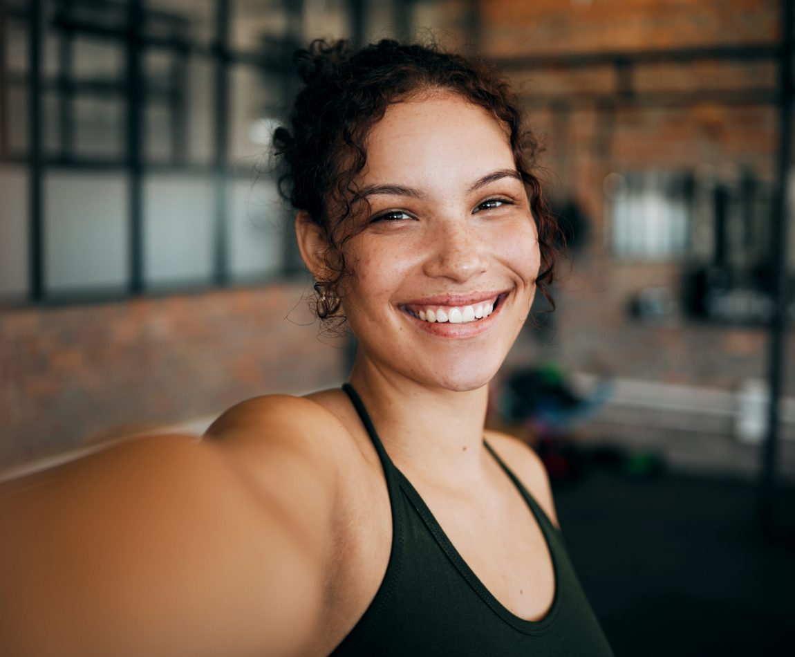 Fitness, exercise and gym selfie portrait of a woman happy about workout, training motivation and body wellness. Young sports female or athlete with a smile for blog inspiration and progress post.